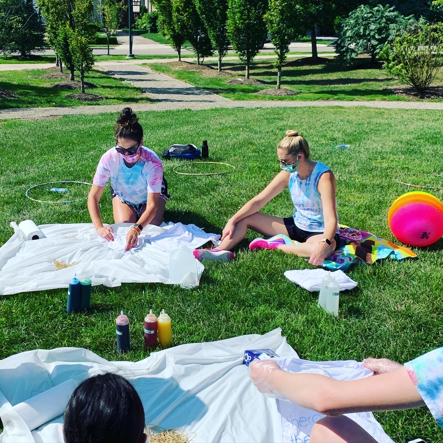 Campers tie-dye shirts in an open grass field at Camp Therapyology. We offer summer camps for teenagers in West Bloomfield, MI. Contact us to learn more about summer programs for teens and summer camp in Michigan