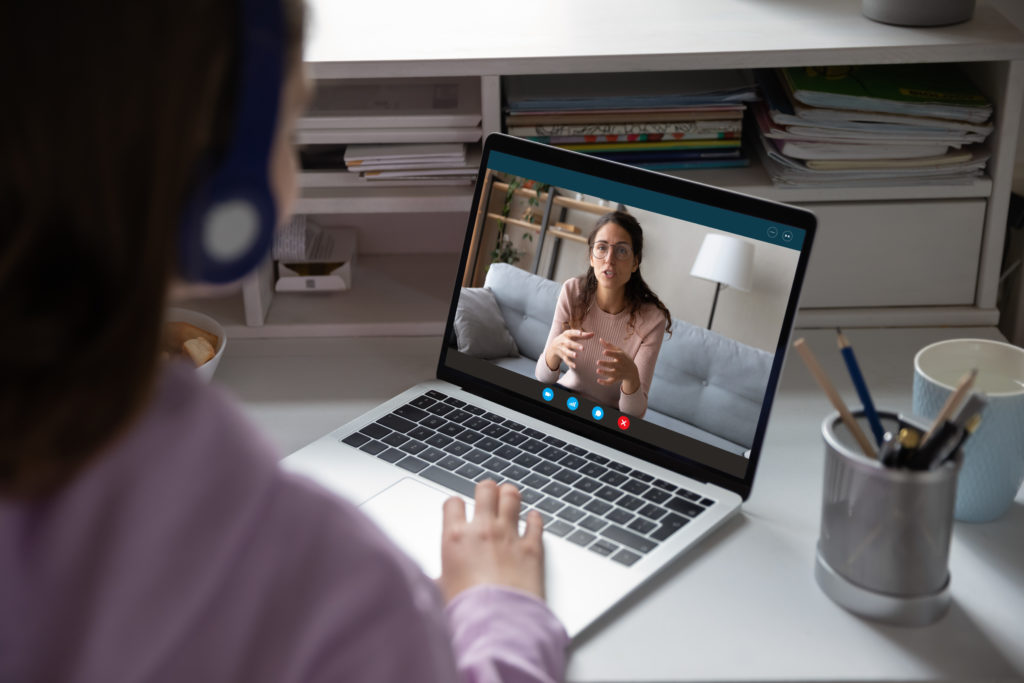 A woman talks with an online therapist over video call on their laptop. This could represent online thearpy in michigan. Contact an online theraipst in michigan for support with online therapy for teens and other services!
