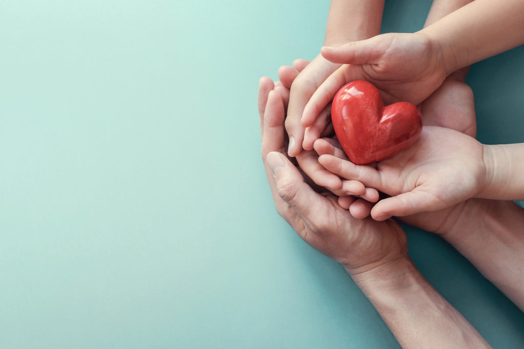 An image of 3 sets of hands cradling a heart for Therapyology. Contact a parenting coach in West Bloomfield, MI for support today. Parent coaching in West Bloomfield, MI and parent support groups in West Bloomfield, MI can offer support today!