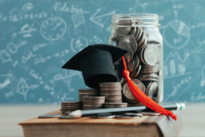 A graduate cap on top of a jar of coins. Representing the difficult decisions and financial investment that comes with life after college that a young adult therapist can help with. Young adult therapy in Farmington Hills & West Bloomfield, MI can help you make the best decisions for you.